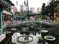 09A A dragon tortoise statue spits out water in the small pond with various pavilions in the Good Wish Garden at Wong Tai Sin temple Hong Kong